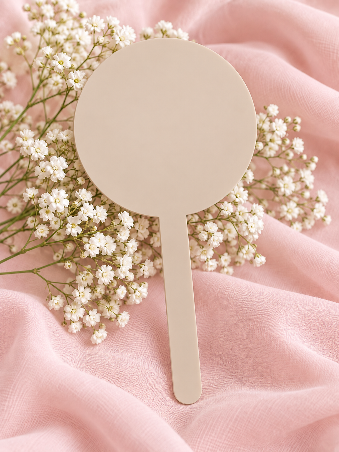 Latte acrylic cake topper on soft pink fabric with baby's breath