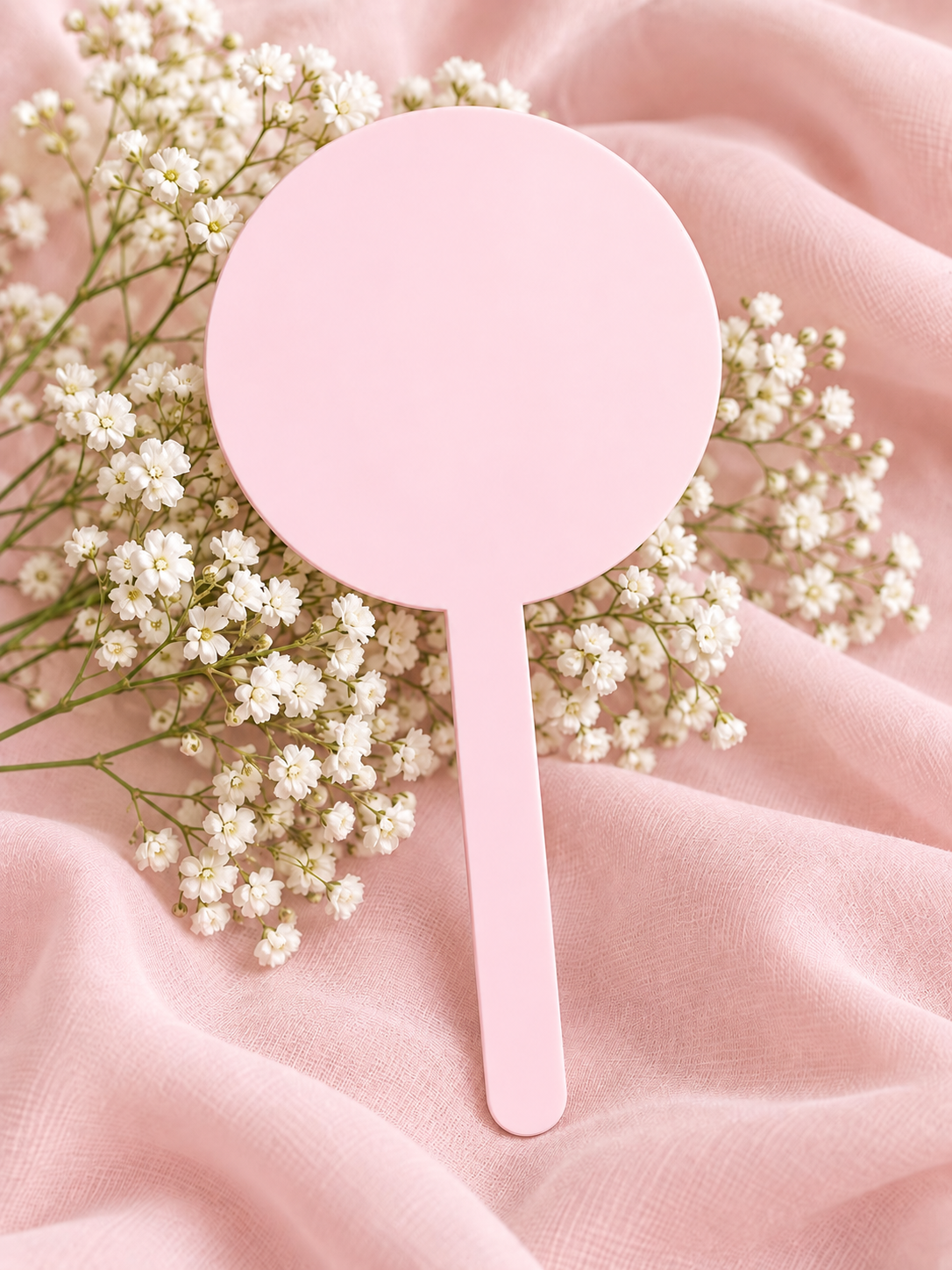 Baby Pink acrylic cake topper on soft pink fabric with baby's breath