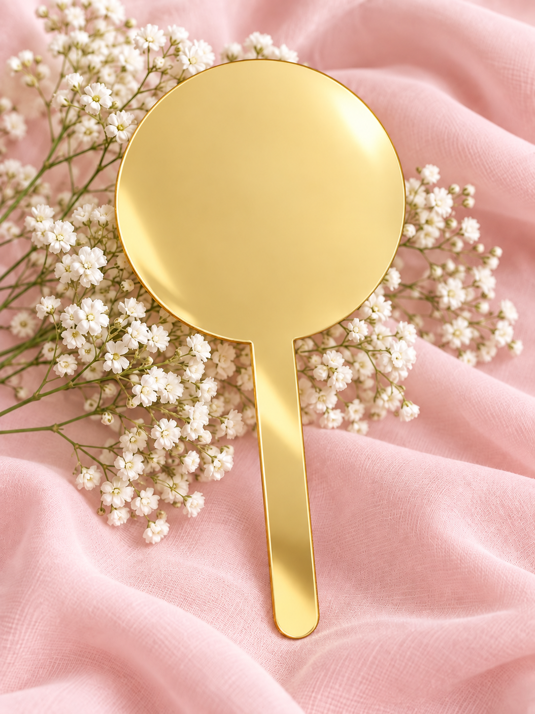Gold Mirror acrylic cake topper on soft pink fabric with baby's breath
