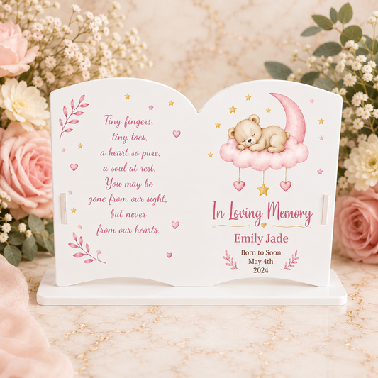 White acrylic open book memorial plaque displayed on a blush floral marble background